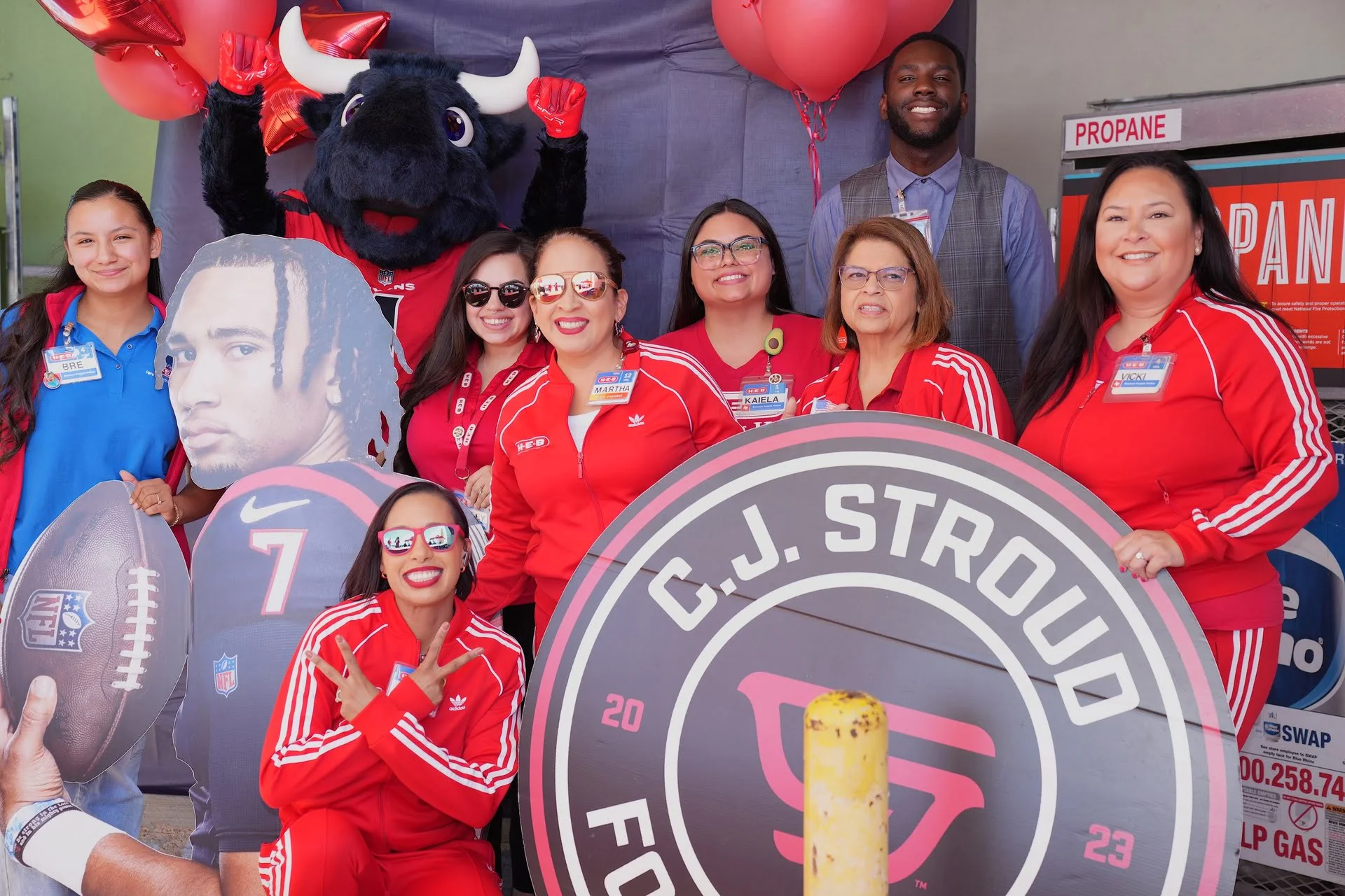 Group posing with mascot and football sign.