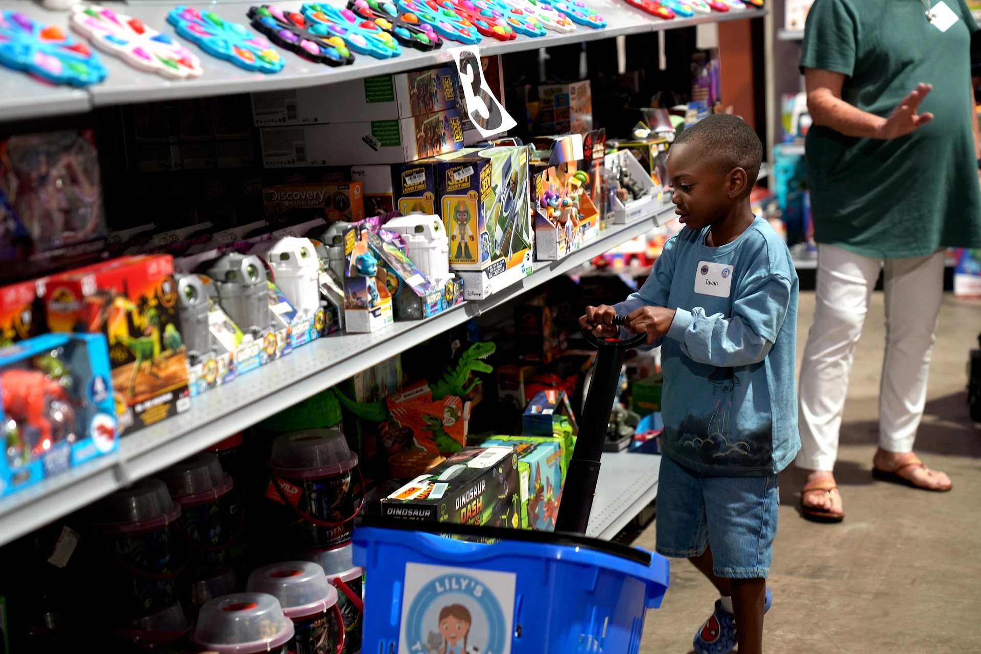 Child browsing toys in a store aisle.