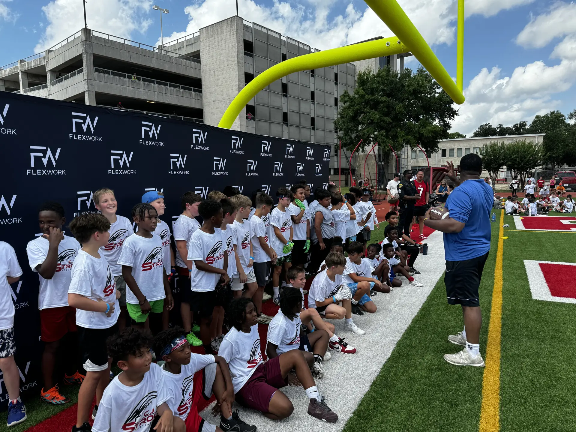 Children gathered on football field sidelines.