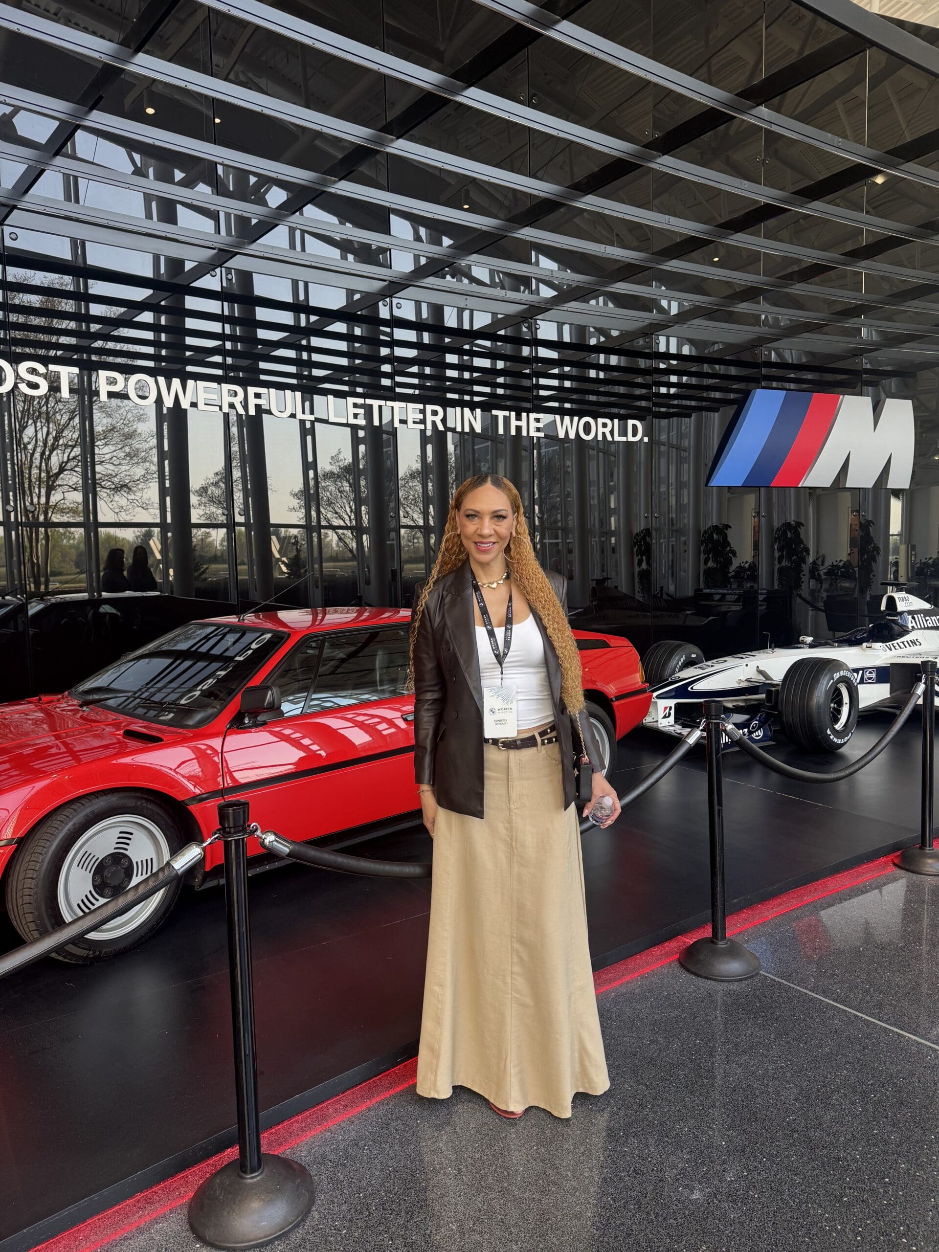 Woman standing in front of classic cars.