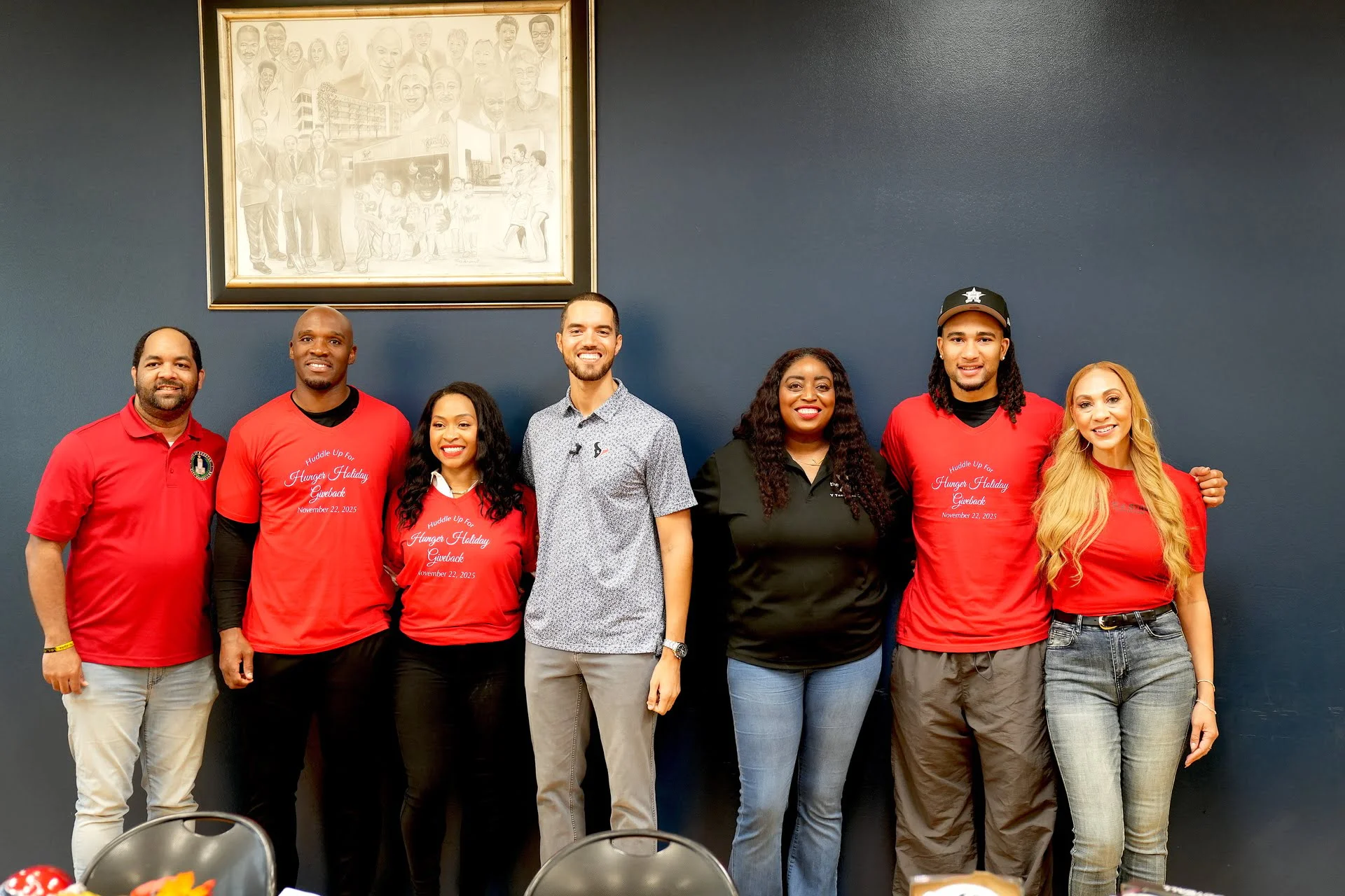 Group of seven people smiling together.