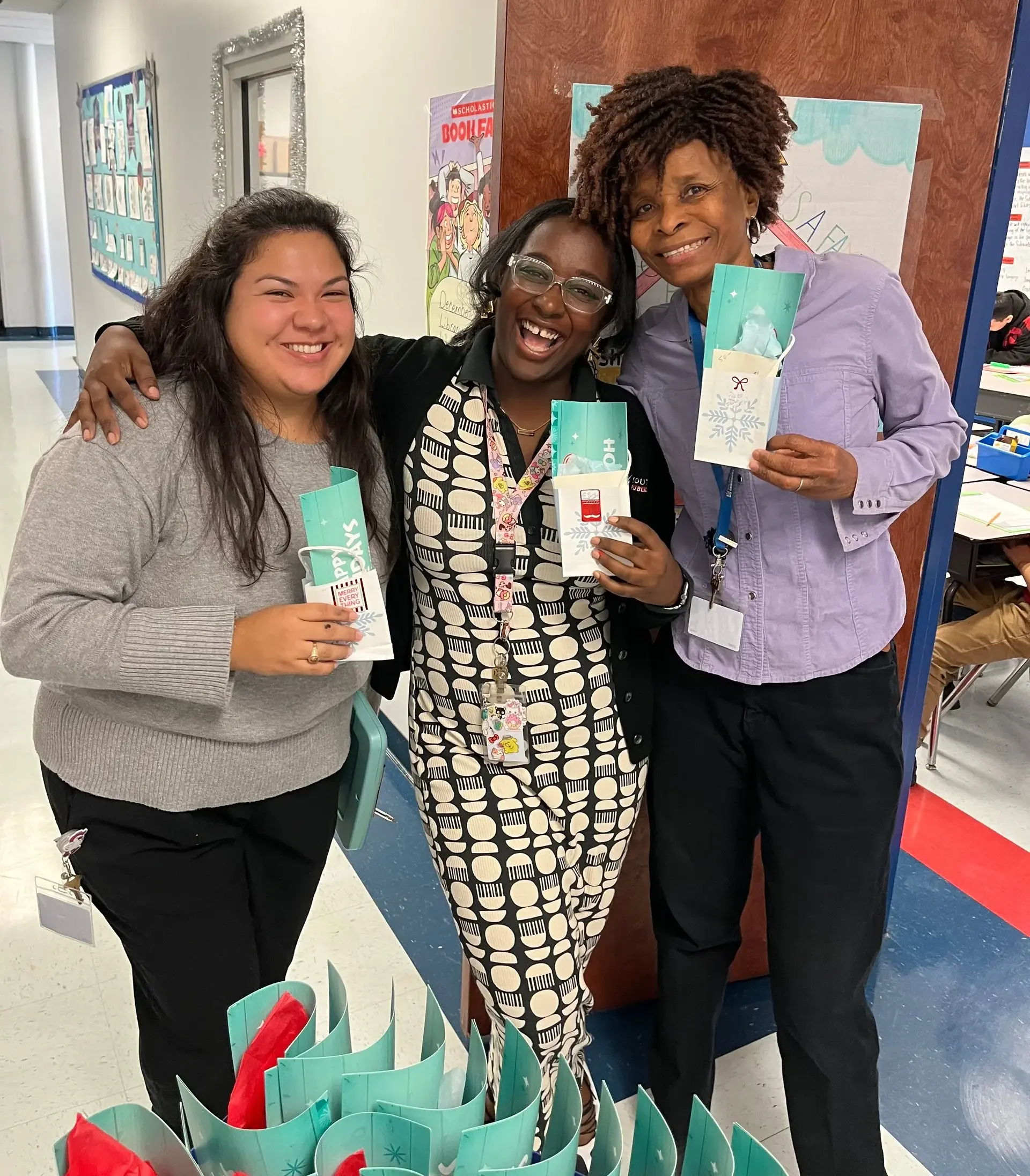 Three people smiling with gift bags.