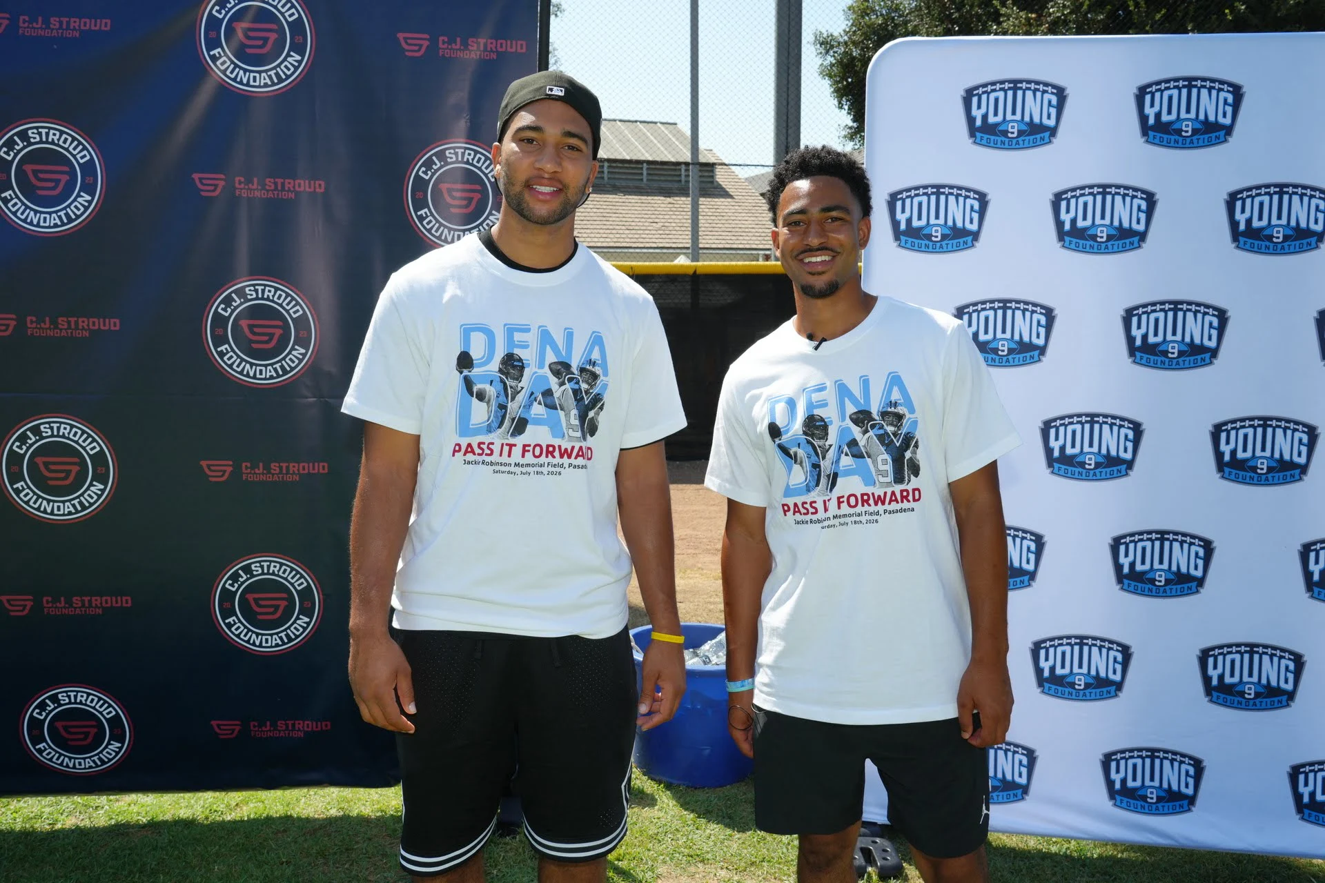 Two men at outdoor event, smiling.