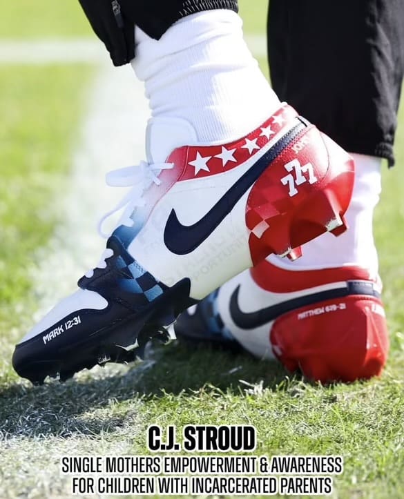 Football cleats with patriotic design and text.