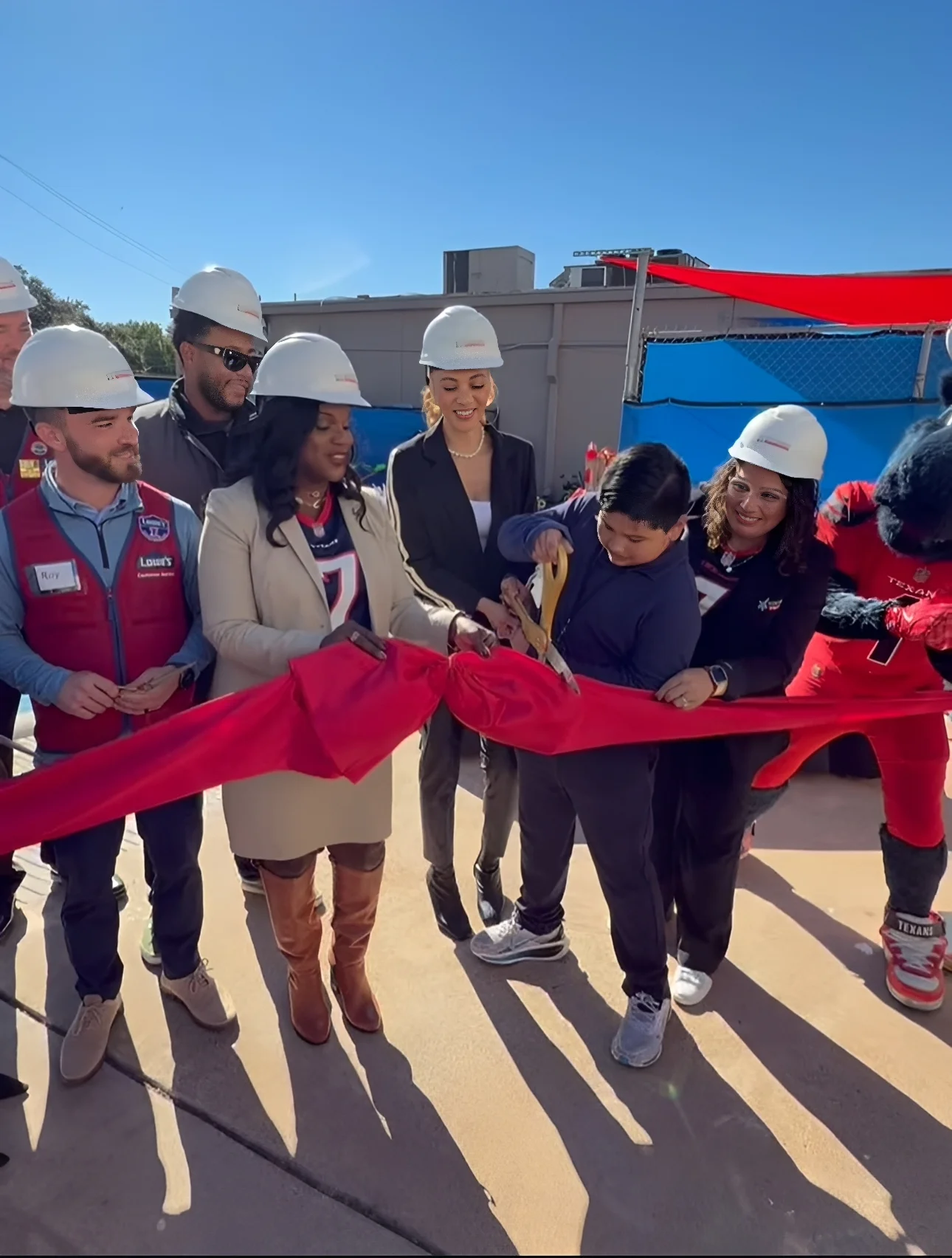 Group in hard hats at ribbon-cutting ceremony.